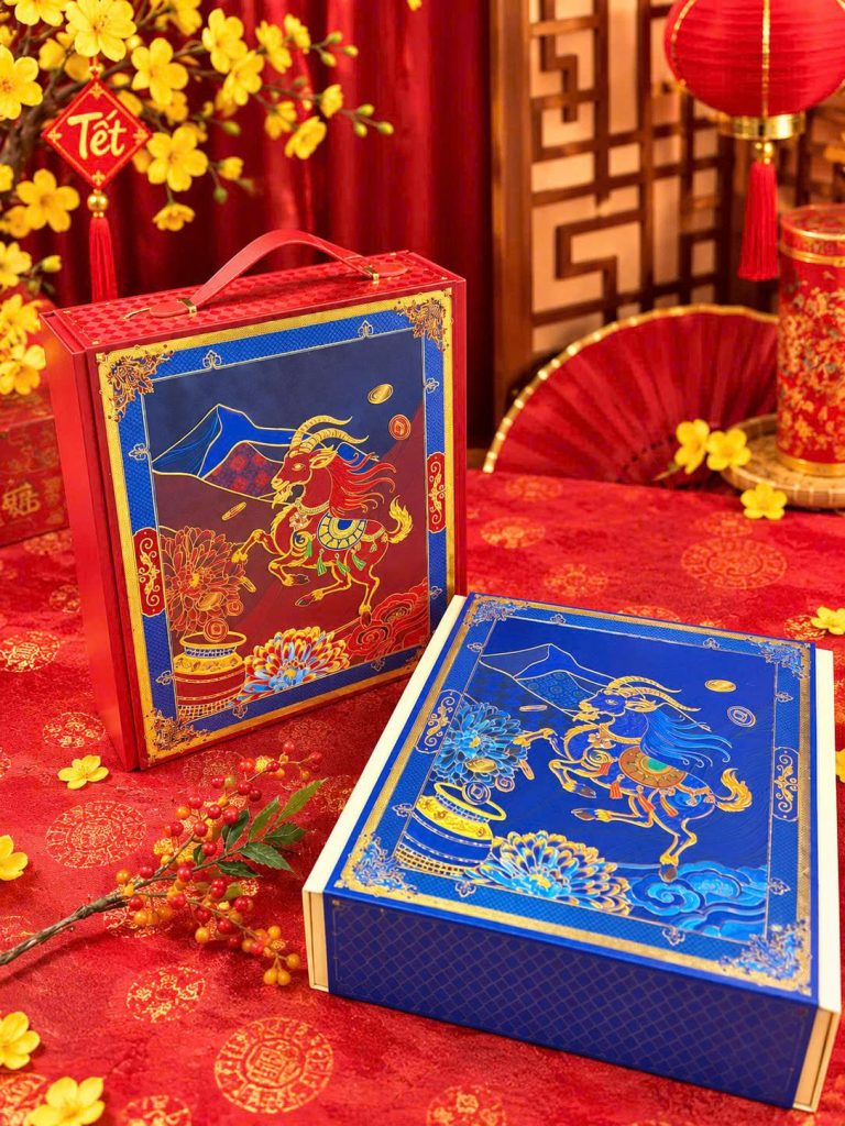 Hai hộp quà tết màu xanh dương họa tiết vàng trên nền đỏ